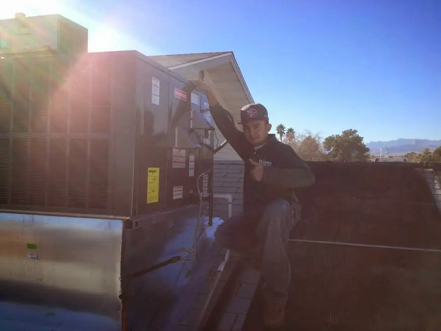 HVAC technician performing Air Duct Repair on a rooftop unit in Clarksville